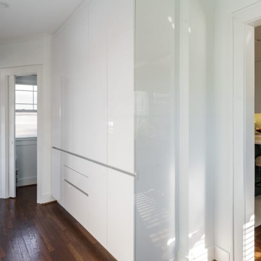 Wall of built-in storage, acrylic white cabinets