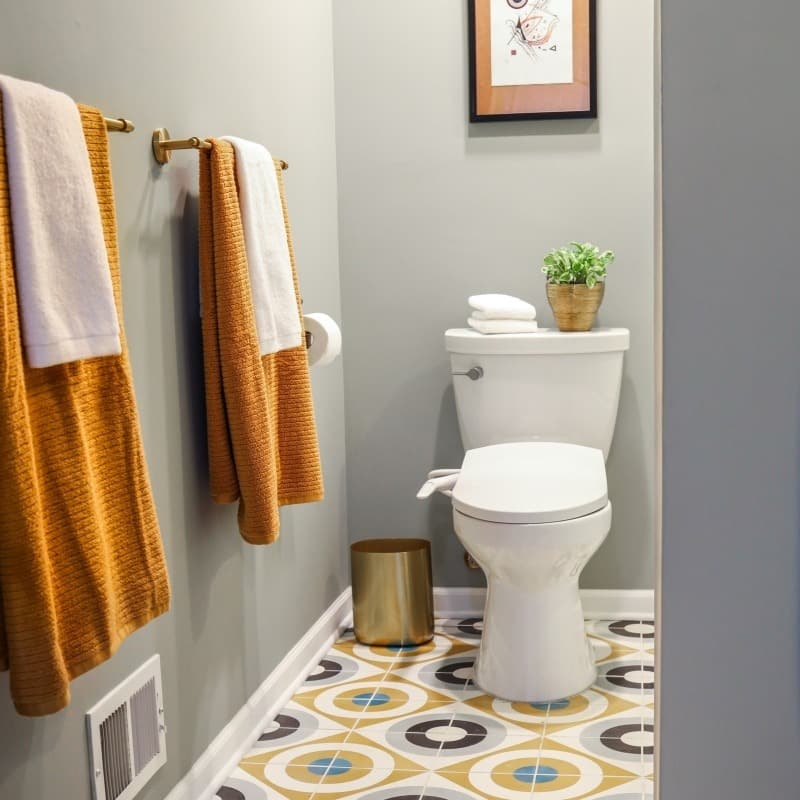 modern bathroom update with bright white shower and navy vanity and brass accents