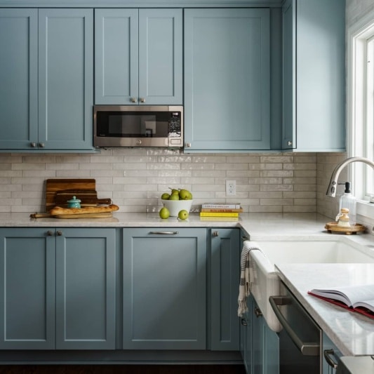 Kitchen with light blue cabinets and white counters