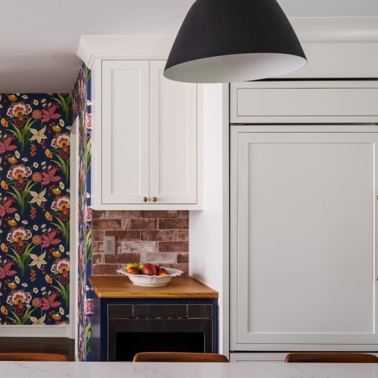 remodeled kitchen with white custom cabinets and gold hardware