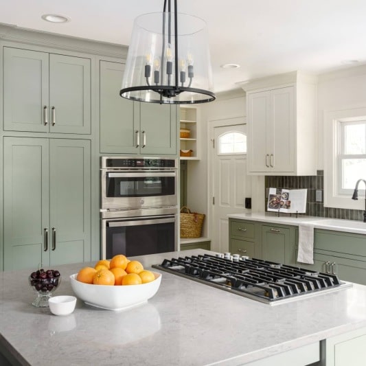 transitional kitchen remodel with sage green cabintry and white upper cabinets for a modern but timeless feel
