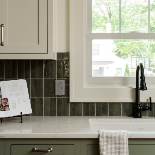 olive green vertically laid zellige inspired tile in kitchen as backsplash at sink