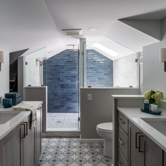 modern spa like wet room with blue subway tile accent and large white soaking tub and grey stained white oak cabinetry for a claming feel in this modern but character filled space
