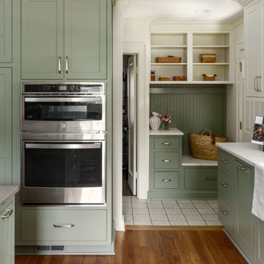 mudroom landing nook at back entry of home on this timeless kitchen remodel featuring sage green cabinetry