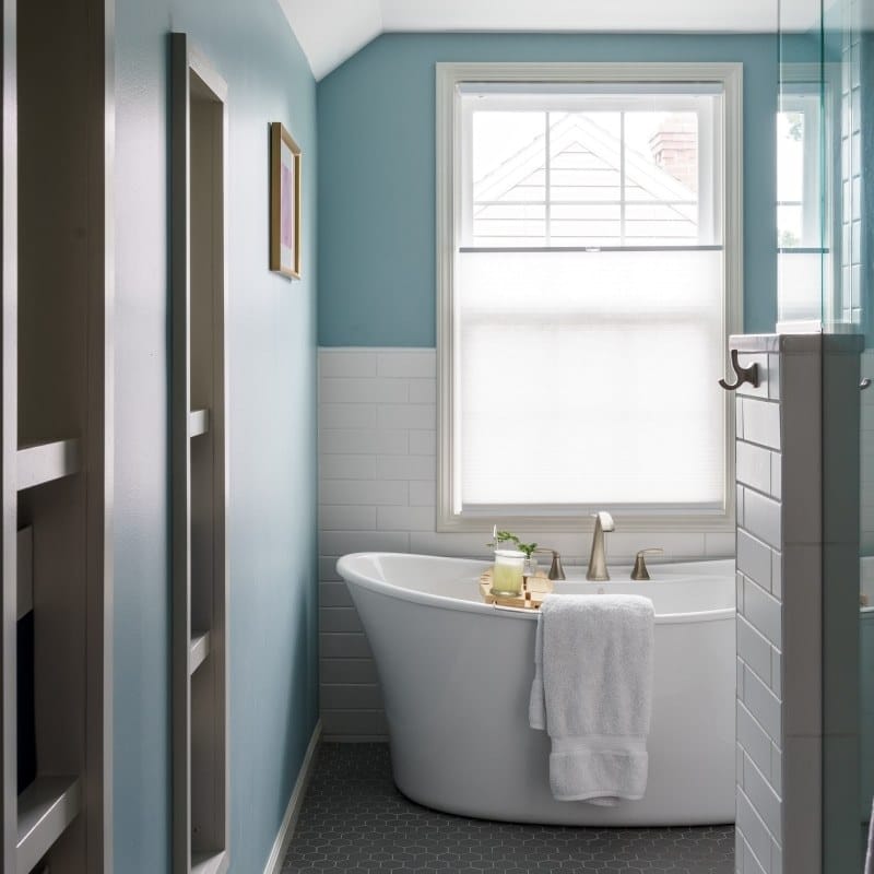 cape cod bathroom remodel with blue accents, large soaking tub, walk-in shower and blue vanity with cambria quartz counters