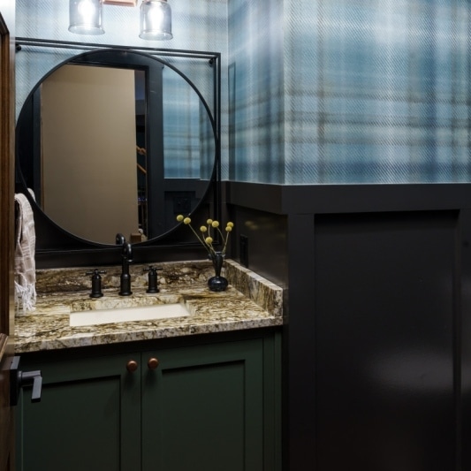 plaid moody powder bath with blue tones for the wallpaper and cabinetry