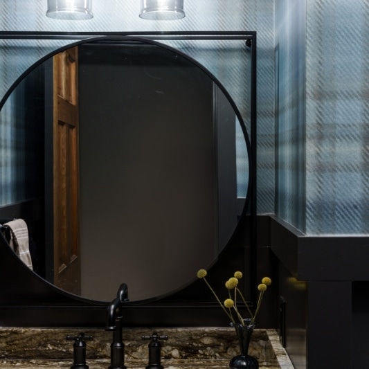 plaid moody powder bath with blue tones for the wallpaper and cabinetry