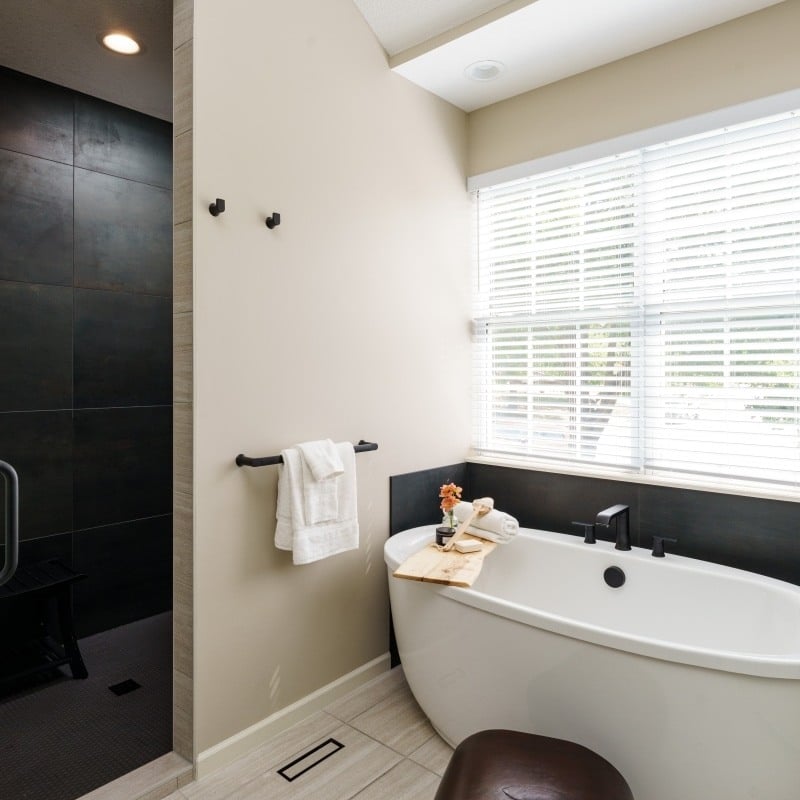 modern sleek spa like bathroom with large soaking tub and dark sleek walk in tiled shower
