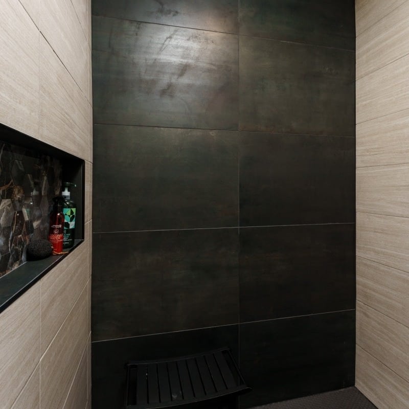 modern sleek dark spa like shower with large format tile and shower niche