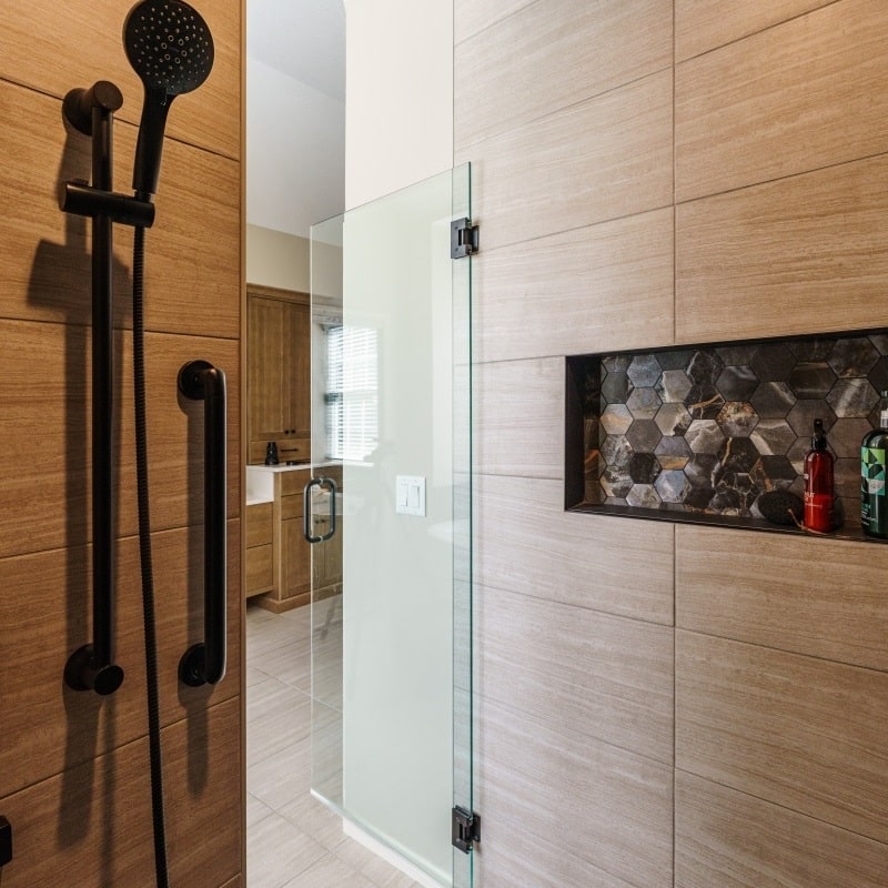 modern shower niche that features hexagon dark stone accent tile
