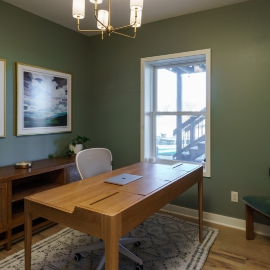 Basement office with green walls, wood desk