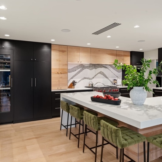 sleek contemporary kitchen remodel with black matte cabinets and white oak and full height backsplash with unique accents