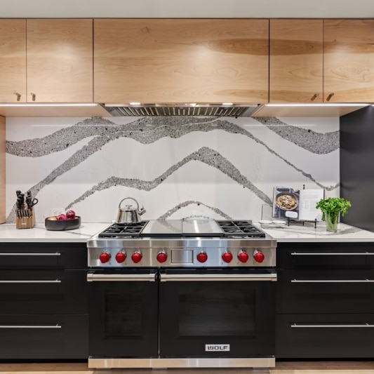 sleek contemporary kitchen remodel with black matte cabinets and white oak and full height backsplash with unique accents