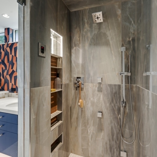 contemporary whole home remodel with retro inspired wallpaper and statement design details in primary suite and bathroom. Navy and burnt orange rust add some personality