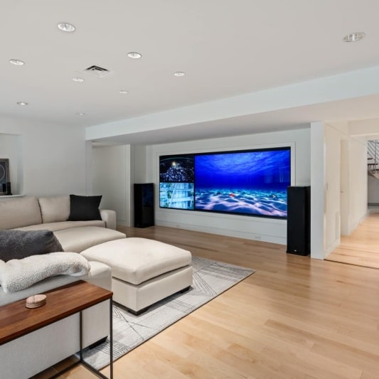 basement of contemporary whole home remodel with a media feature wall and various tvs