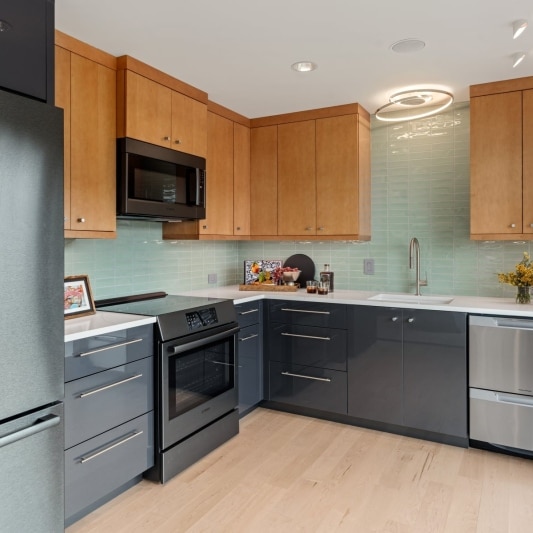 contemporary basement kitchen with mint tile and black and warm white oak cabinetry to add contrast