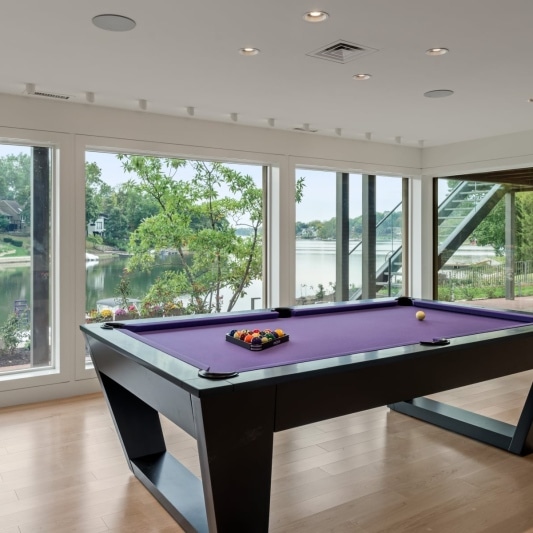 basement of contemporary whole home remodel with view out to lake and pool table in the corner