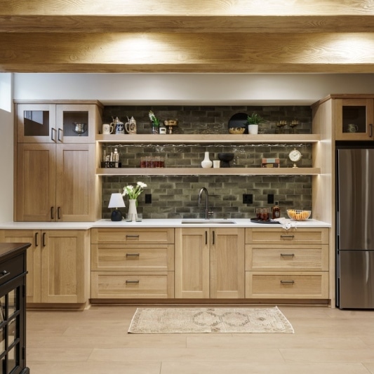 Basement bar with white oak cabinets and green tile backsplash