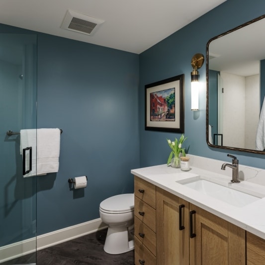 Bathroom remodel with white oak, scones, and glass shower door