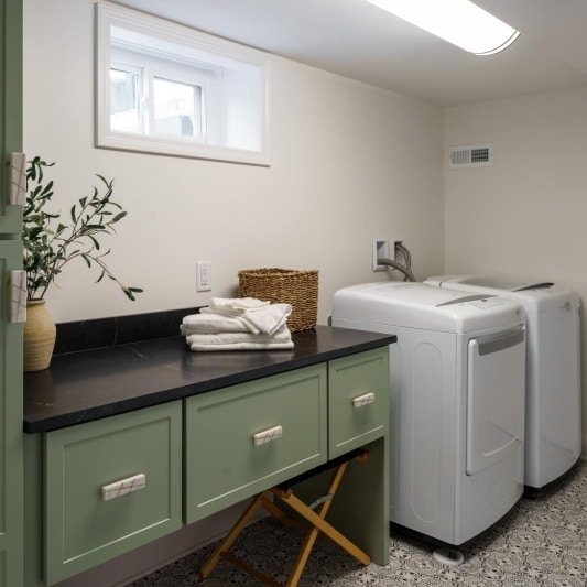 Laundry room with green cabinetry black granite tops and printed vinyl tile floors