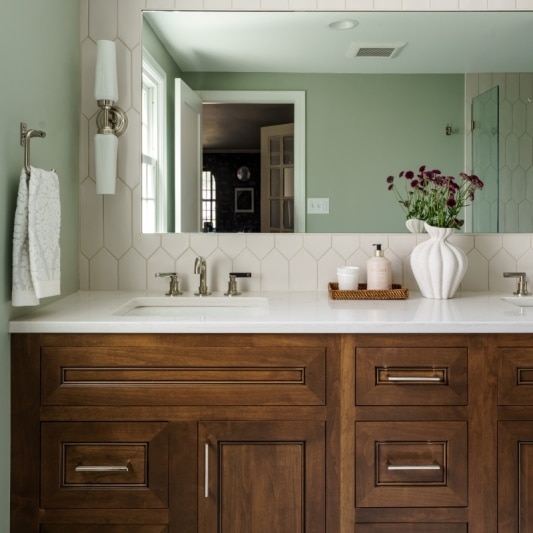 modern primary bathroom remodel with dark wood vanity cabinetry and bright shower tile