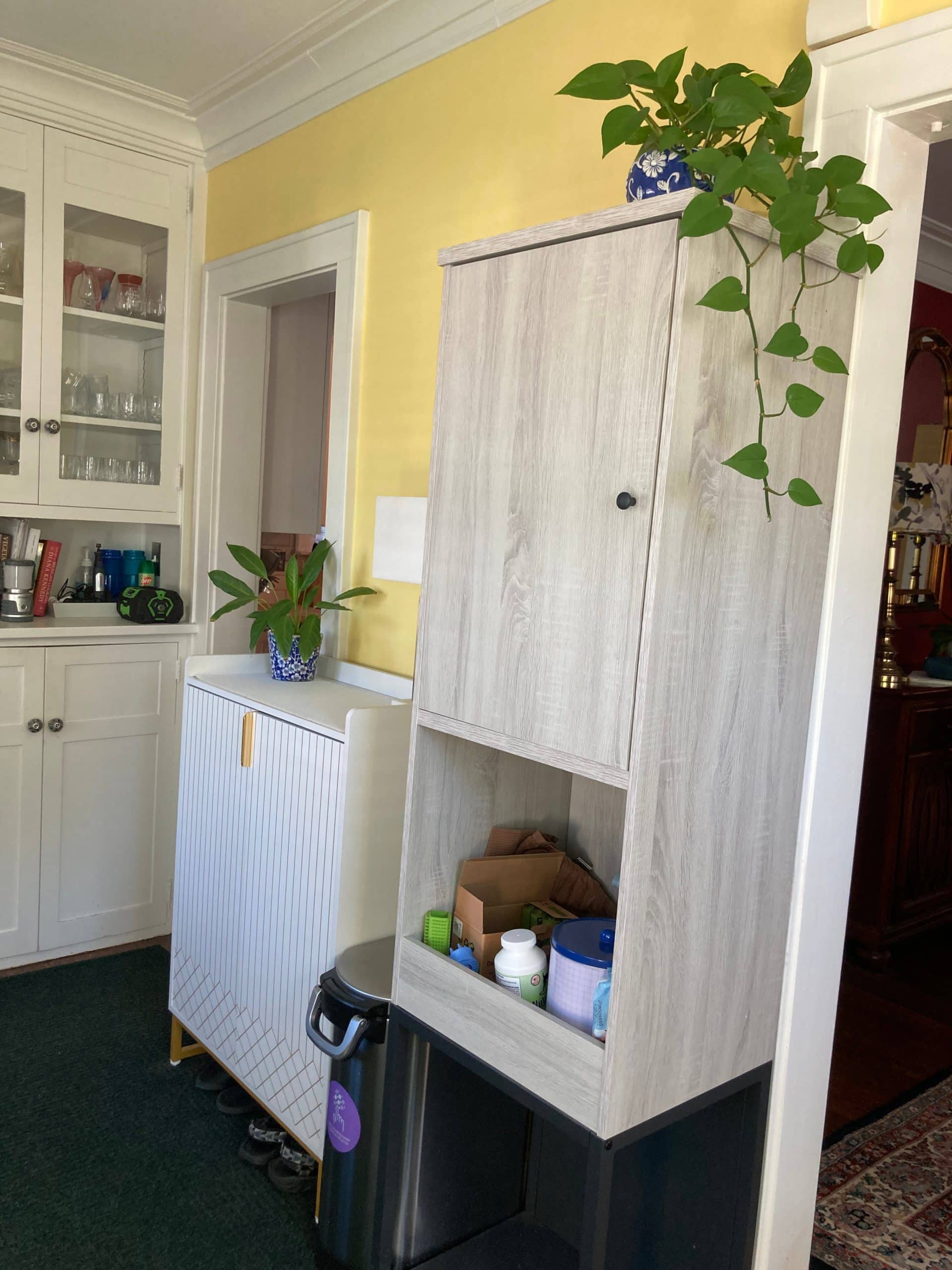 before photo of the sunroom area where there are a lot of small cabinets and shelves added since there isn't good pantry storage. we will soon re do this wall and create plenty of storage and pantry space all down the wall