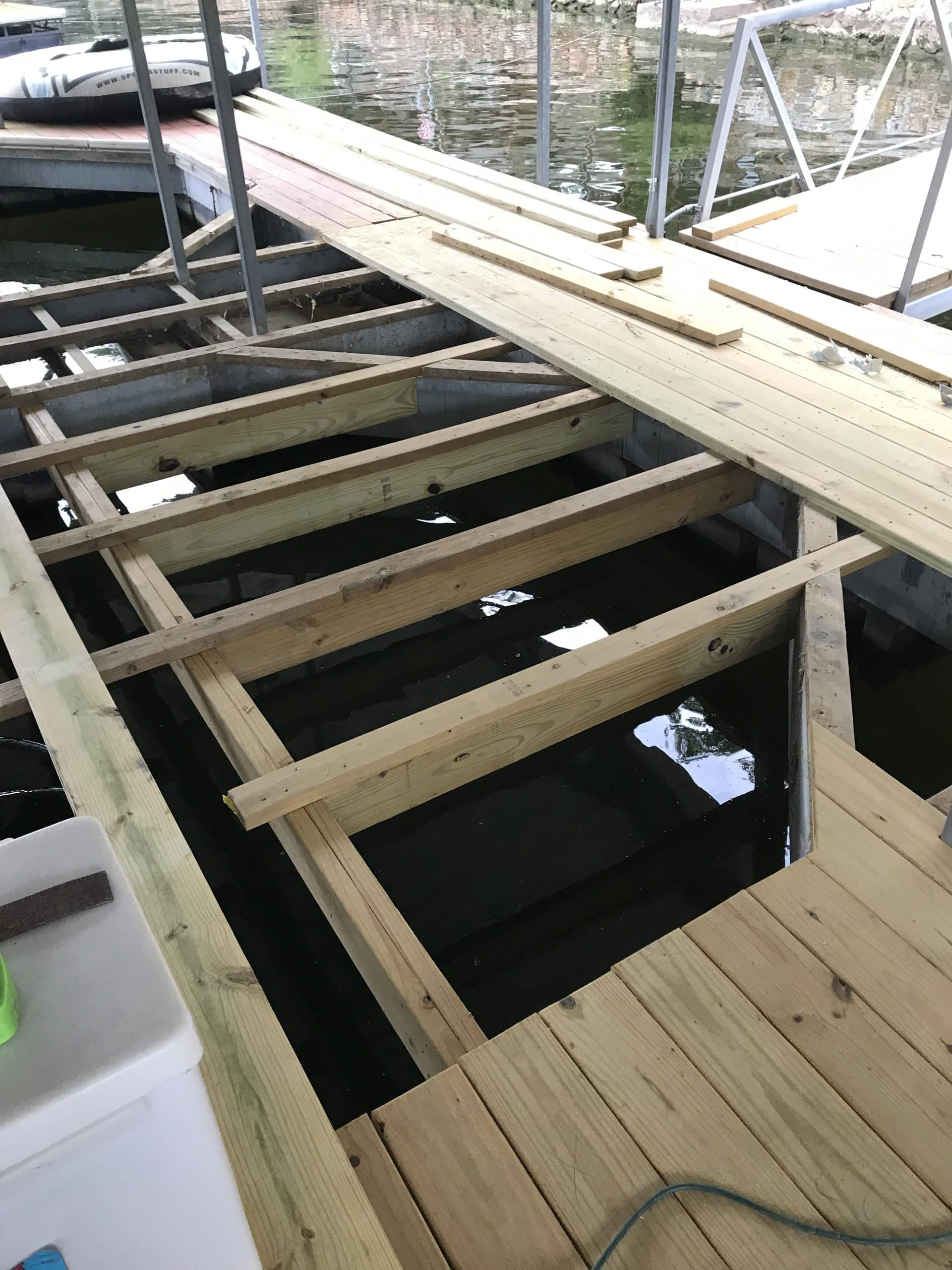 image of dock where some boards are missing but the underneath stud strong boards are still there as we are mid replacing them