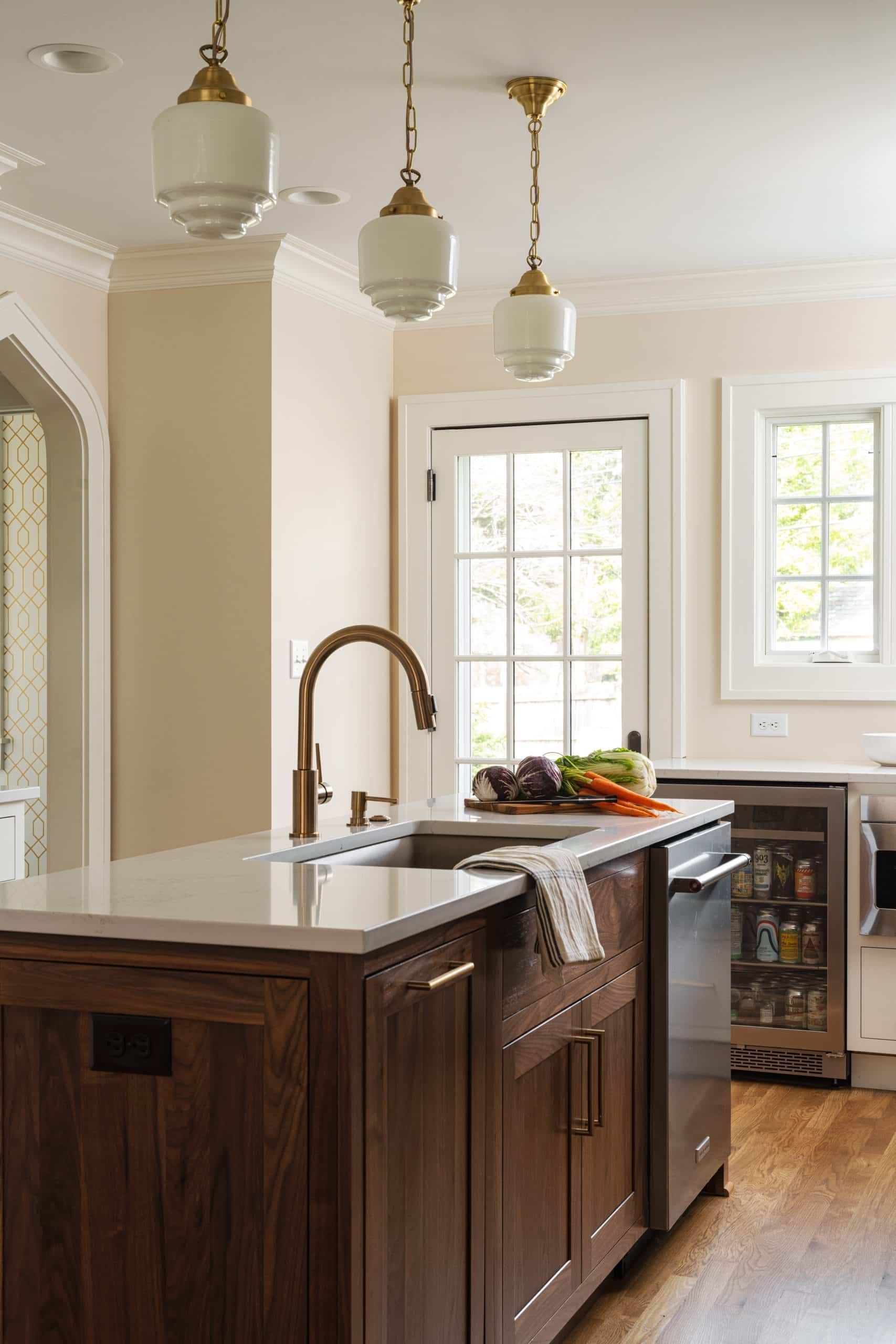 after image of brookside kitchen with warm oak island and gold and white pendants hanging over island