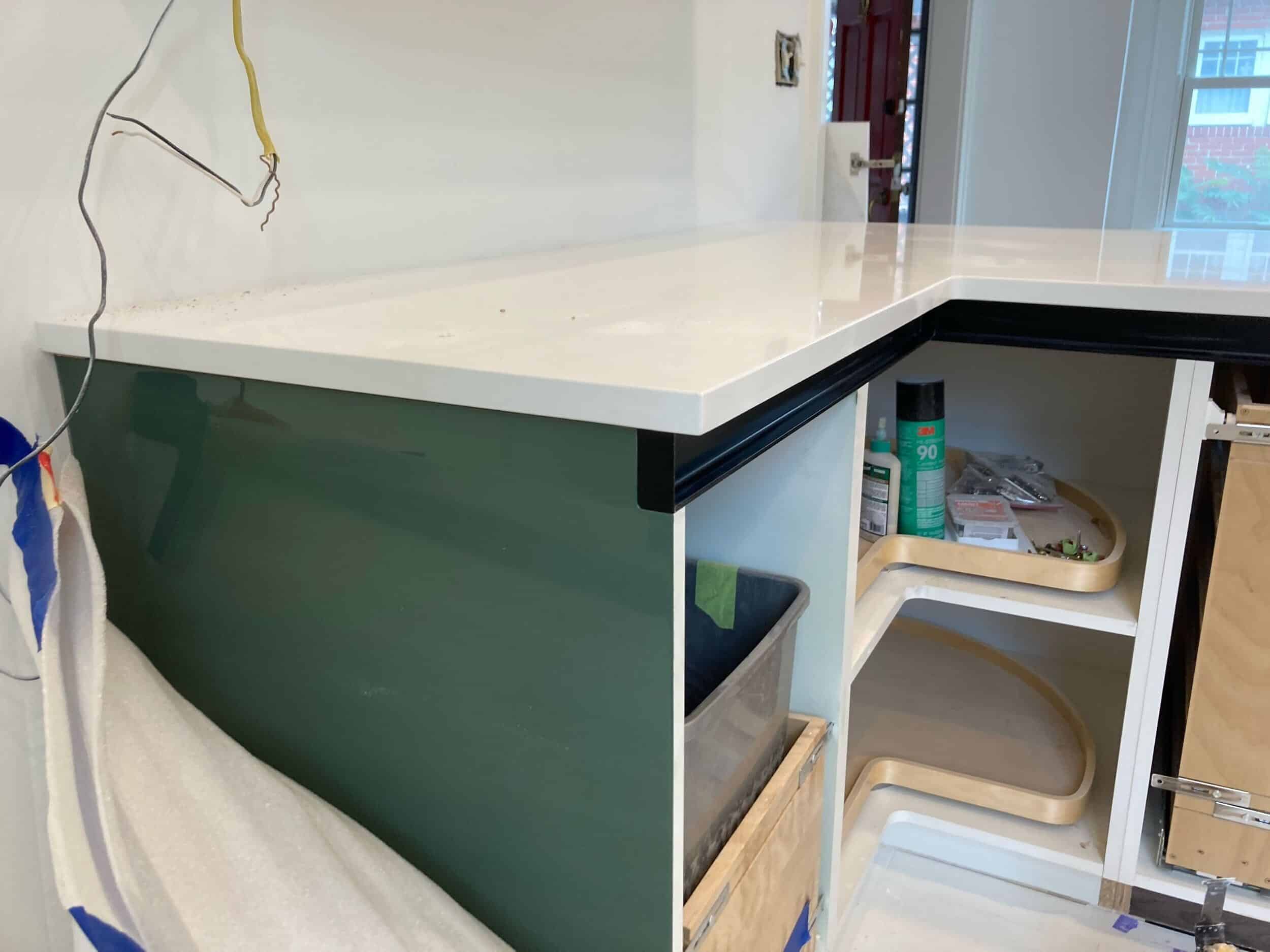 the unique green shade of high gloss custom cabinets is shining through after we removed the sticker to protect from dust or scratches