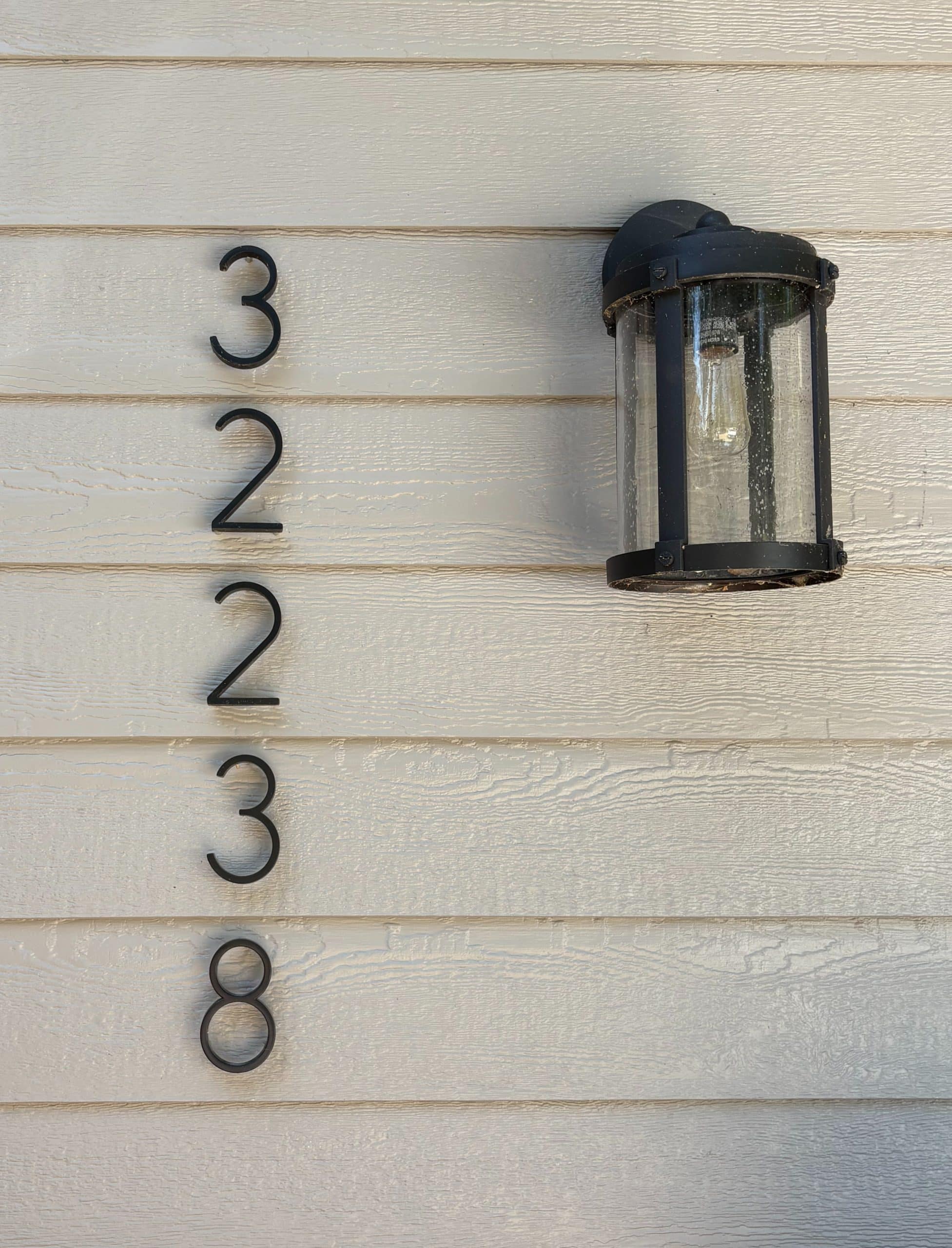 modern sleek thin house numbers reading 32238 with black sleek lamp type light fixture