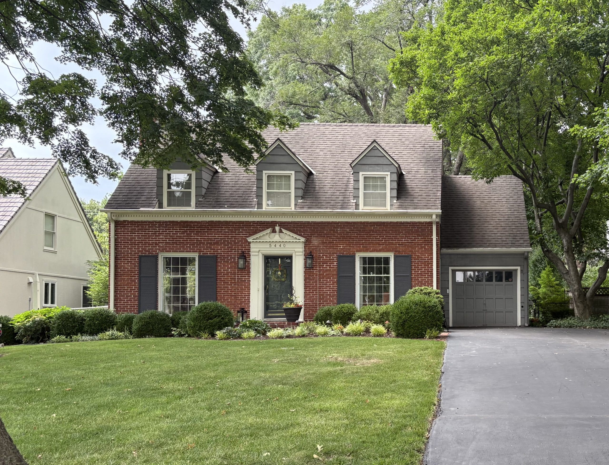 cape cod brick home with three dormers on top