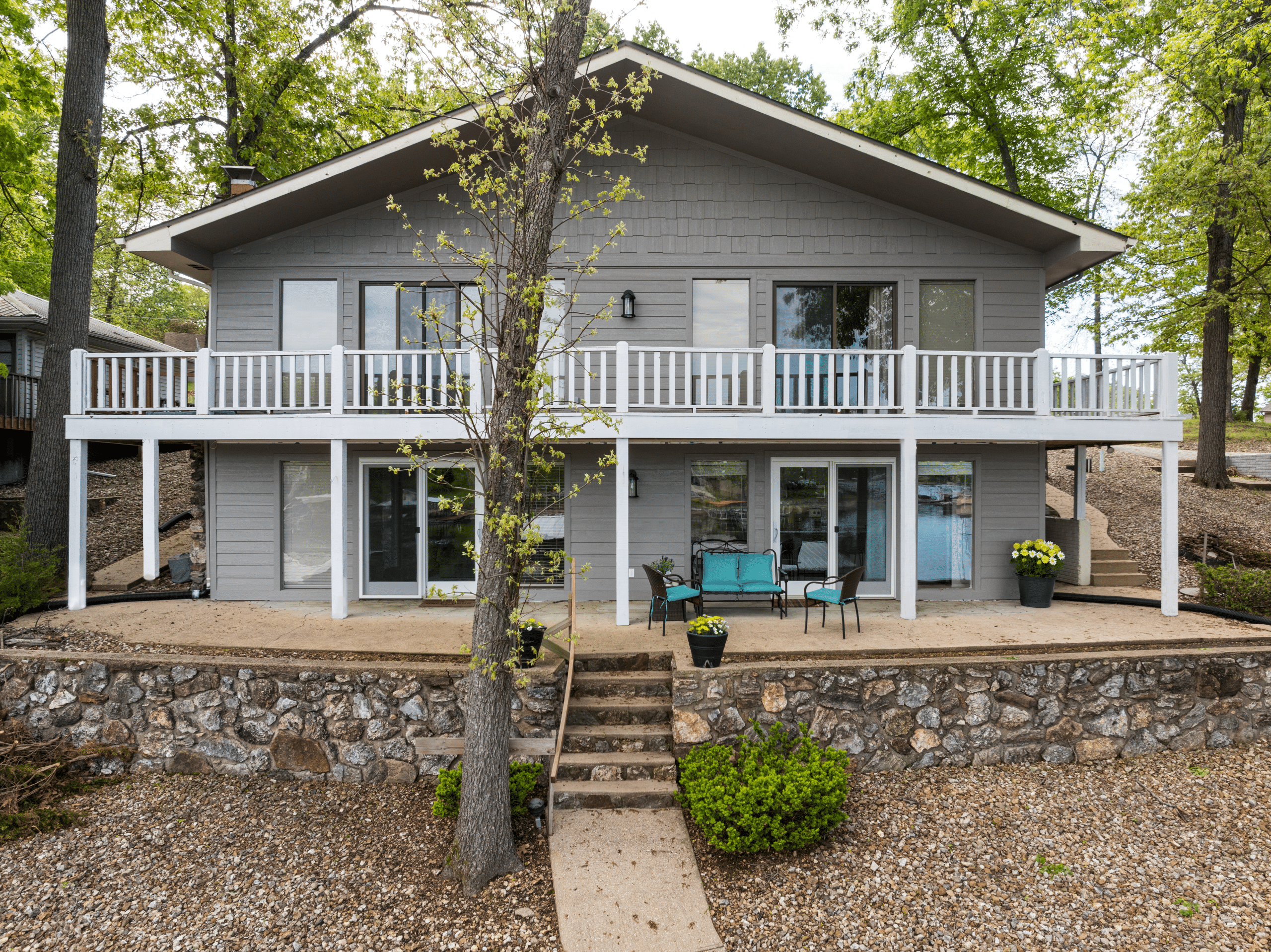 lake of the ozarks home after a refresh with a grey exterior and fresh white painted deck for a crisp clean look