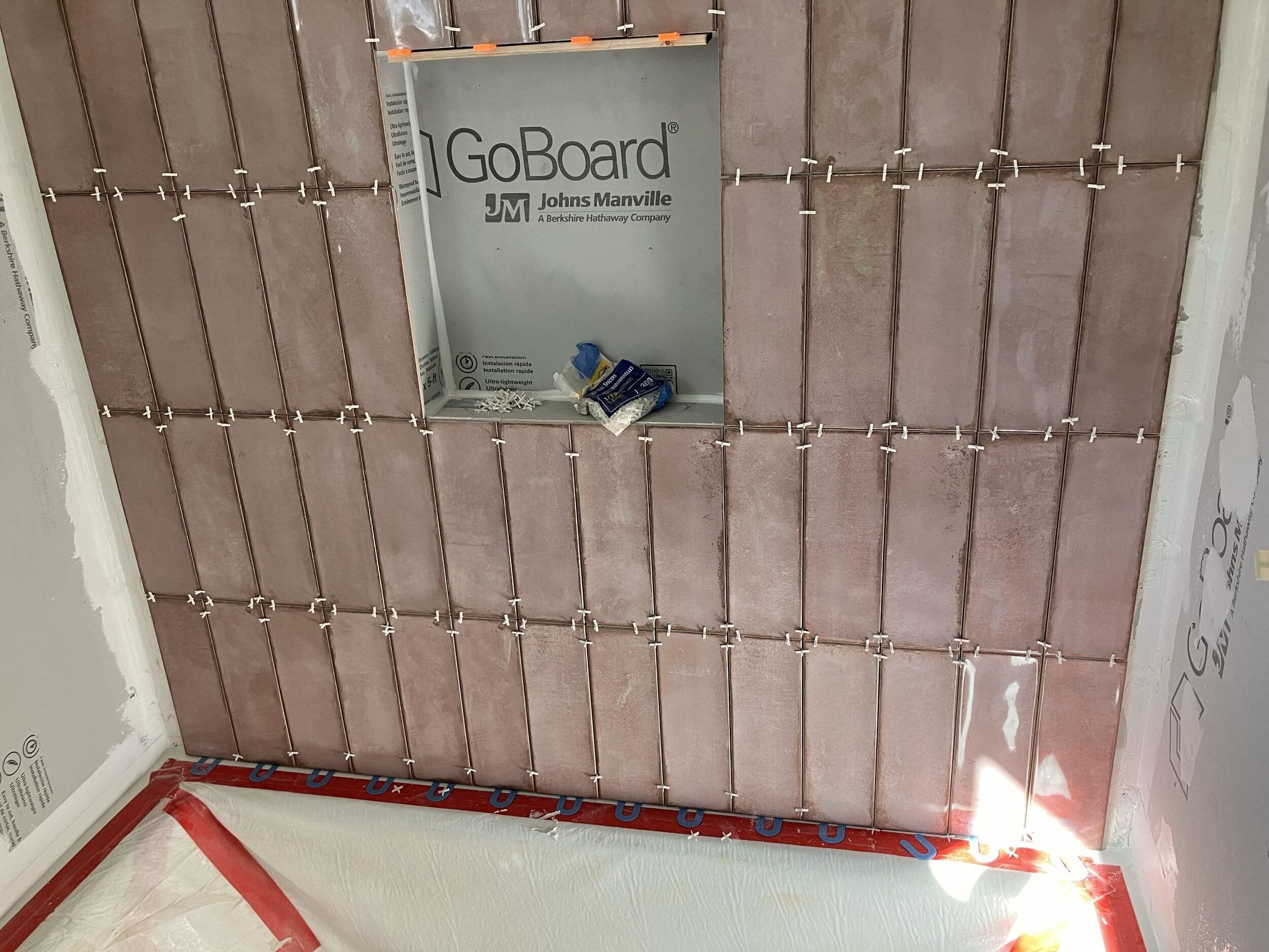 pink shower tile being laid