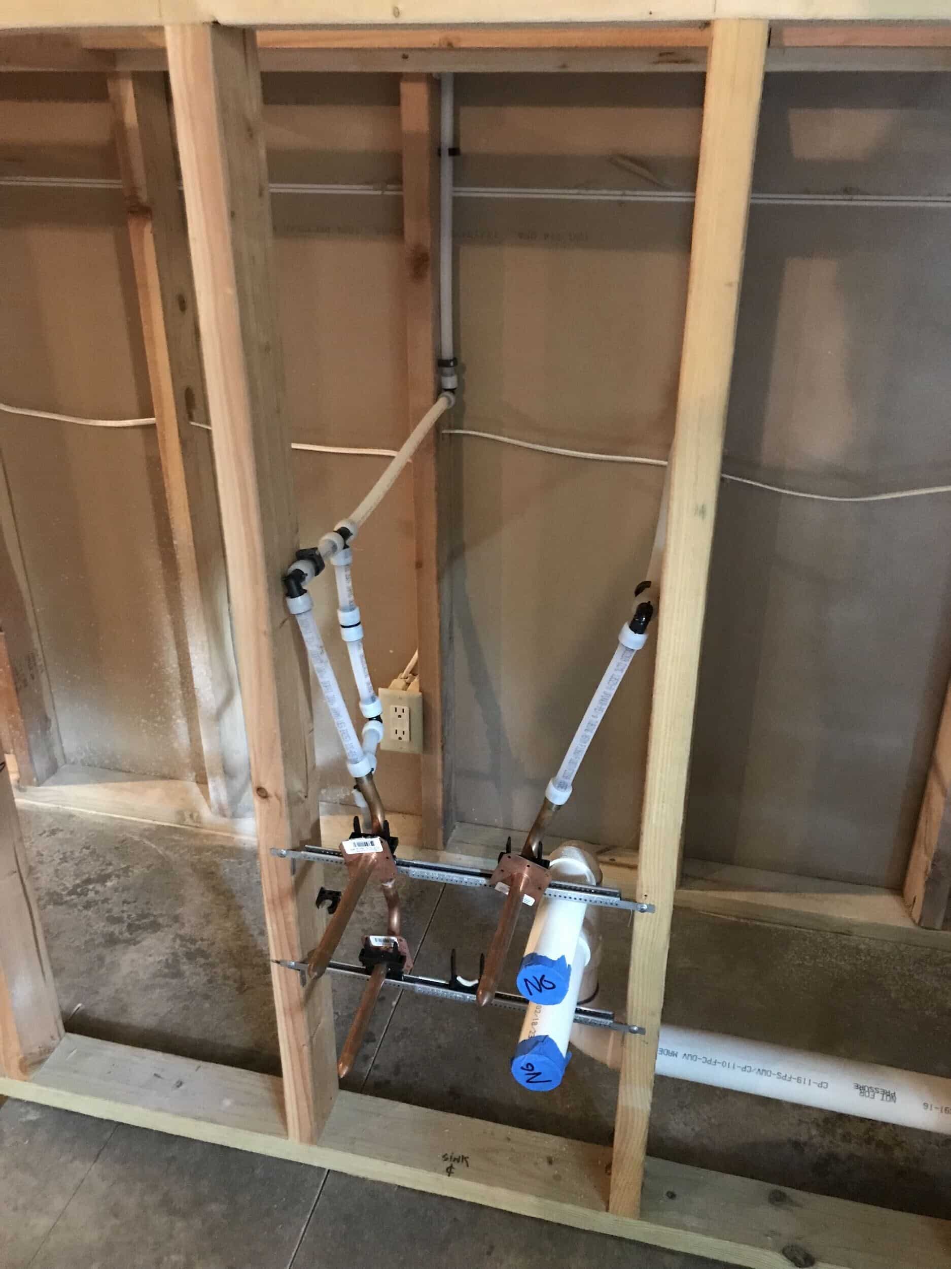 plumbing rough in pipes in opened up exposed wall in the remodeling basement project