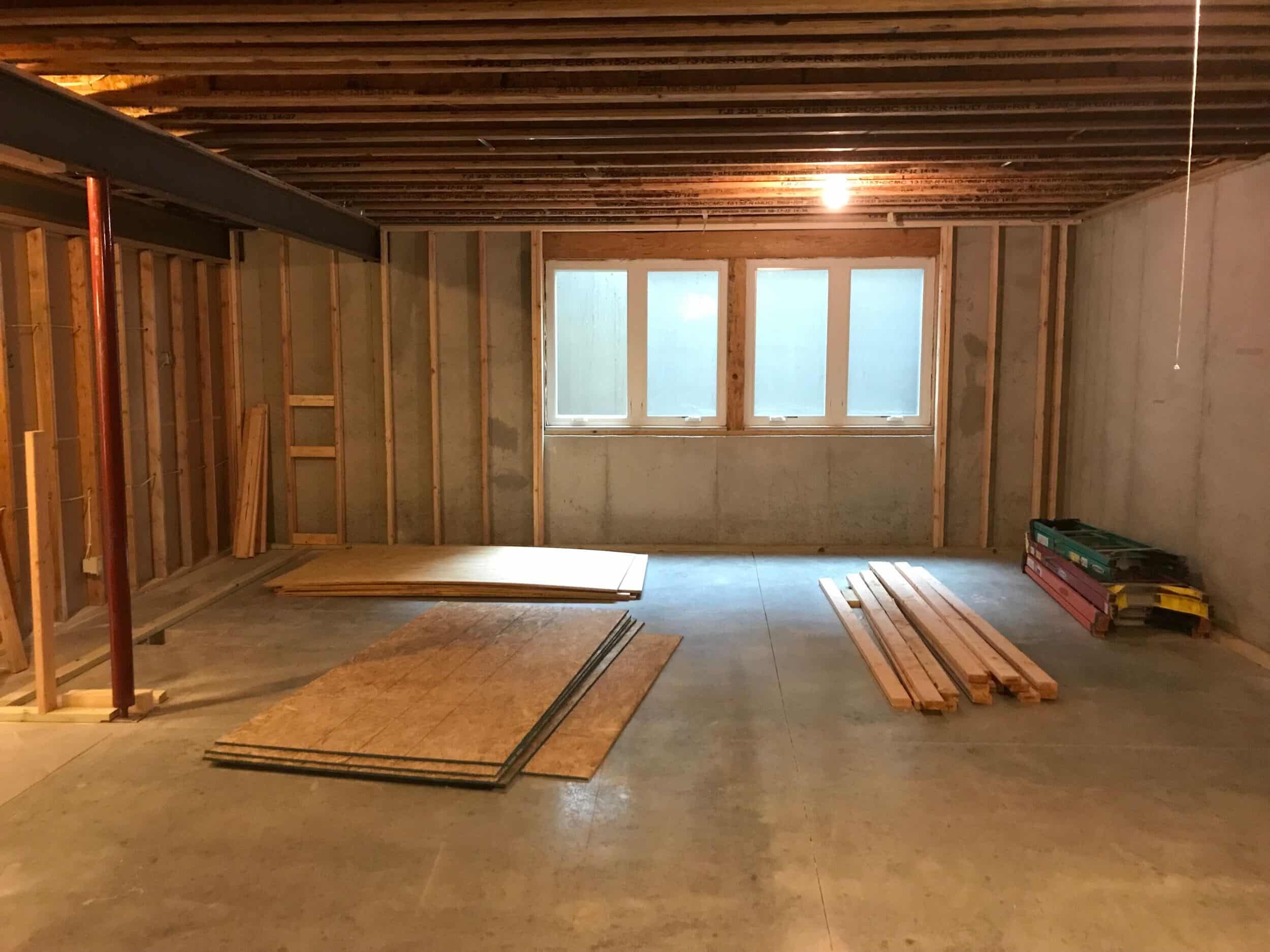 basement framing in leawood remodel with concrete floors and concrete perimeter walls. the new warm wood framing is up creating seperate spaces 