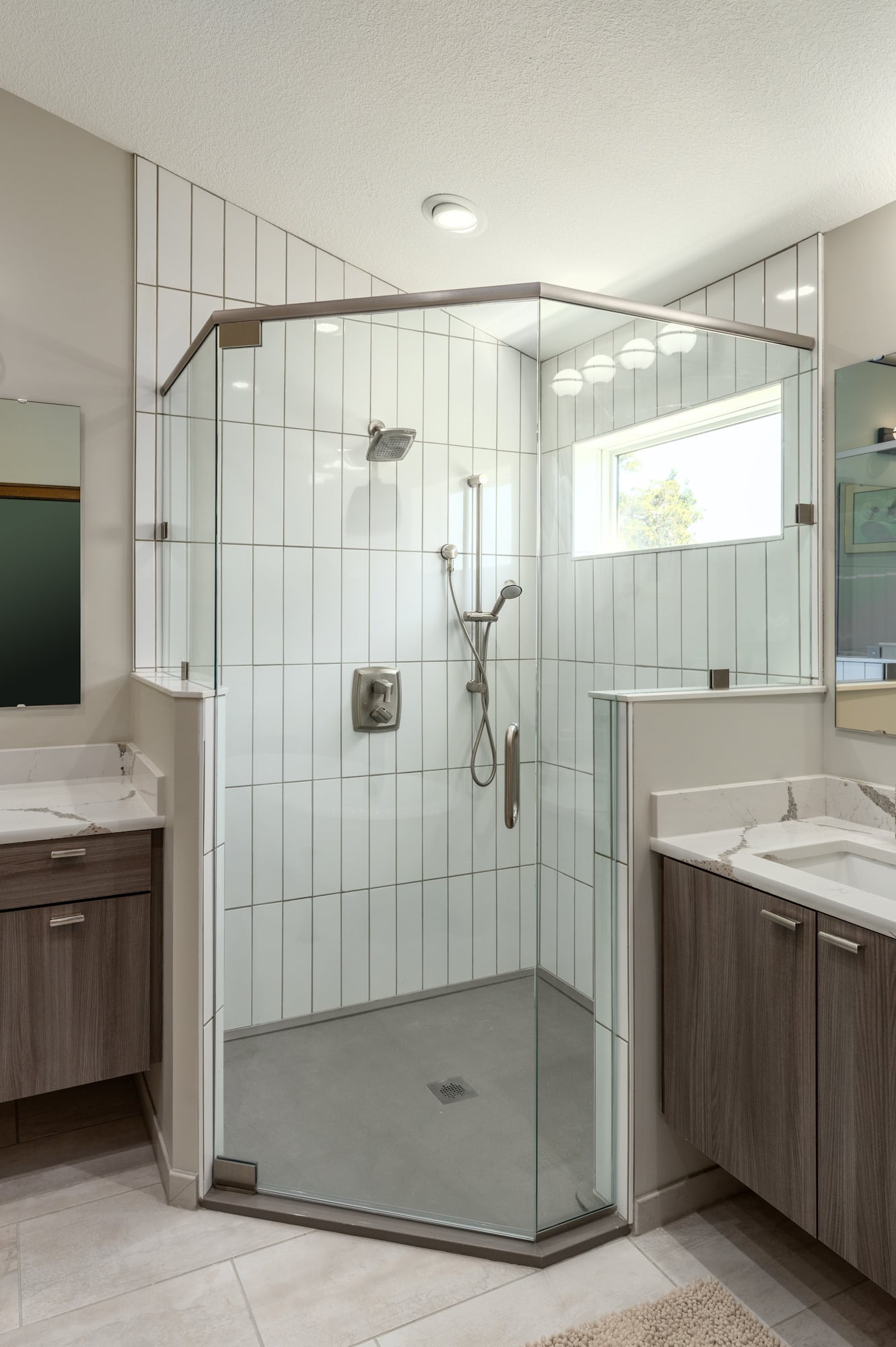 neo angle corner shower door with half pony wall and vanities on either side in large bathroom 