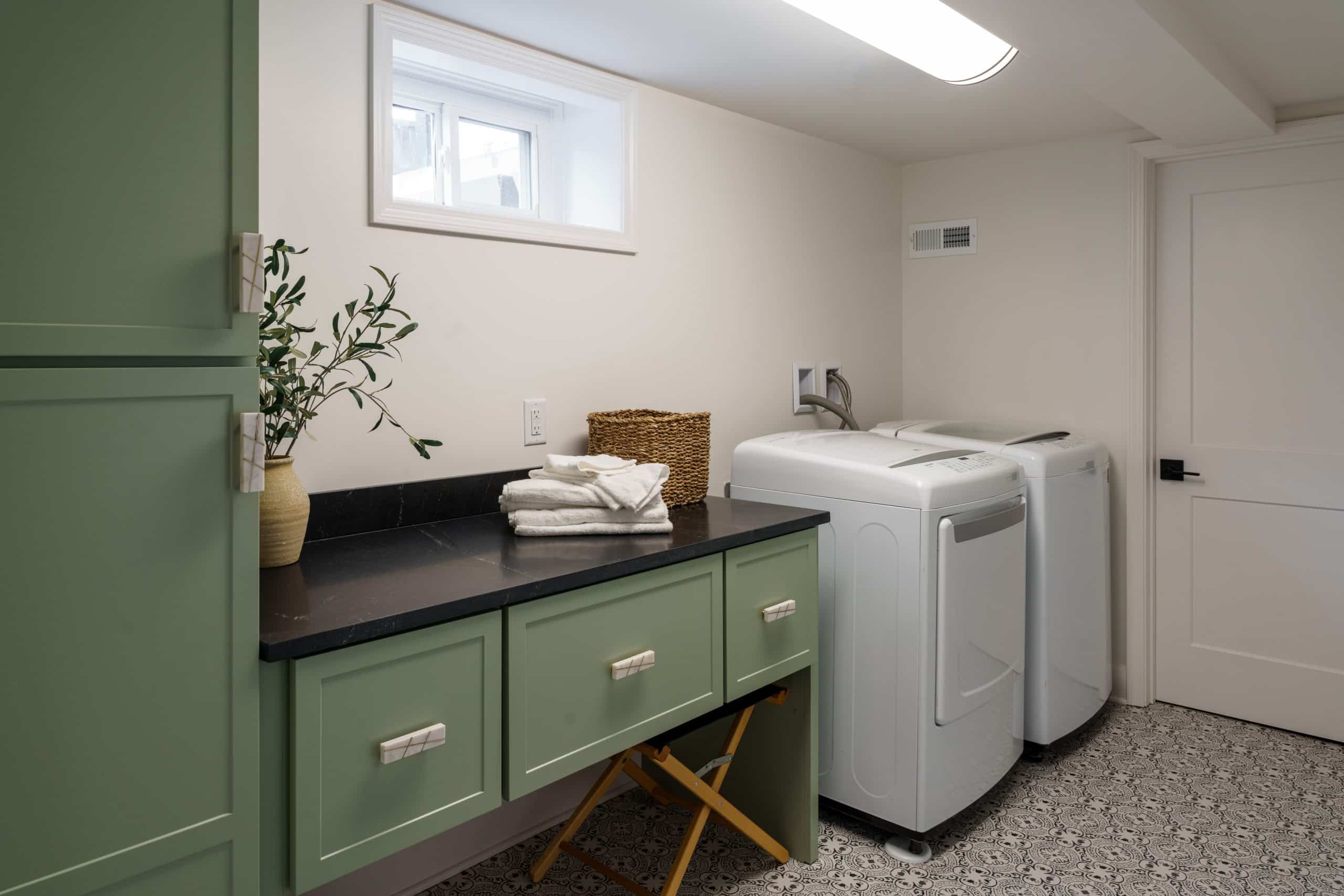 modern laundry room in prairie village basement remodel with green custom cabinets