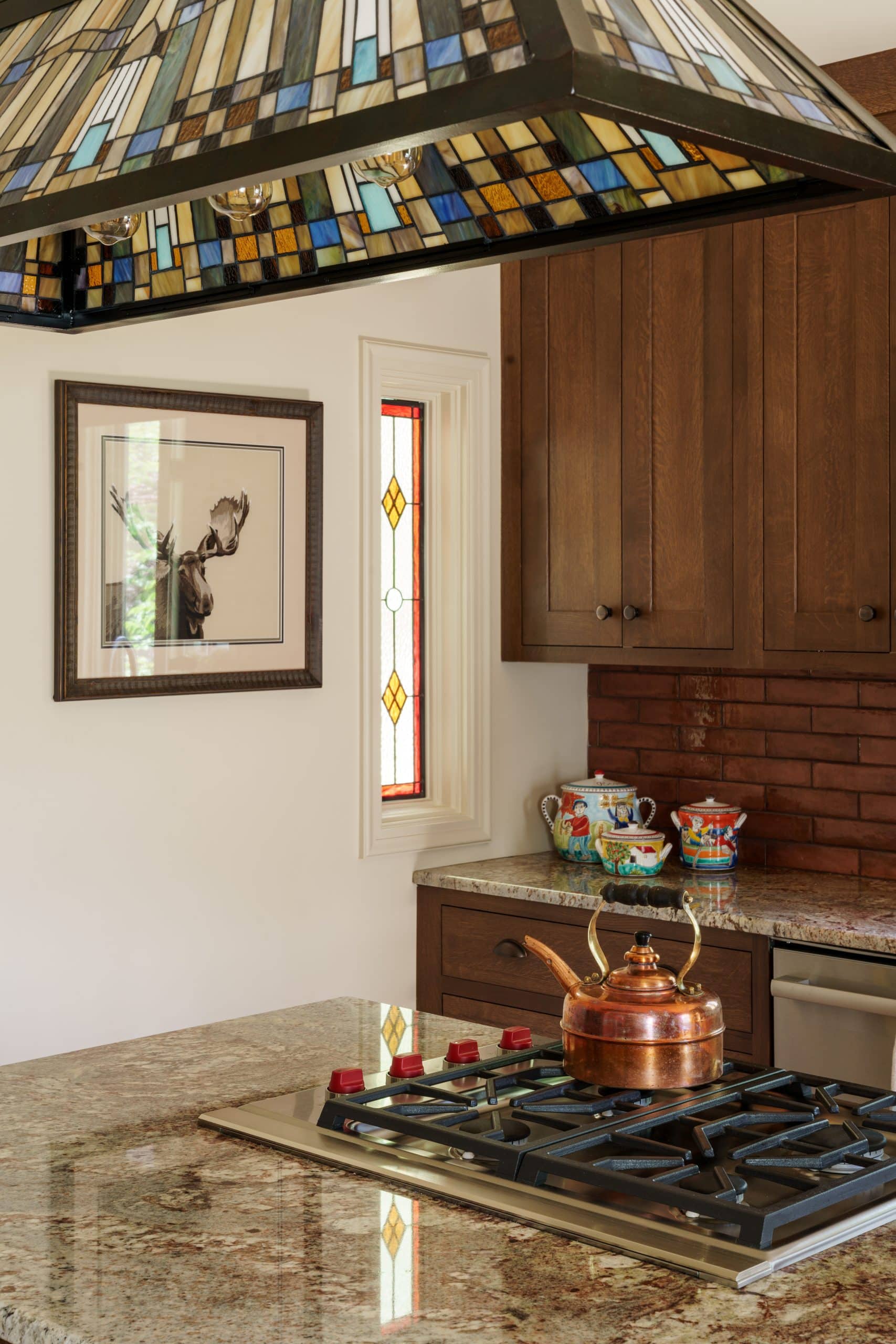 vertical details of warm wood tone charming craftsman kitchen in armour hills 
