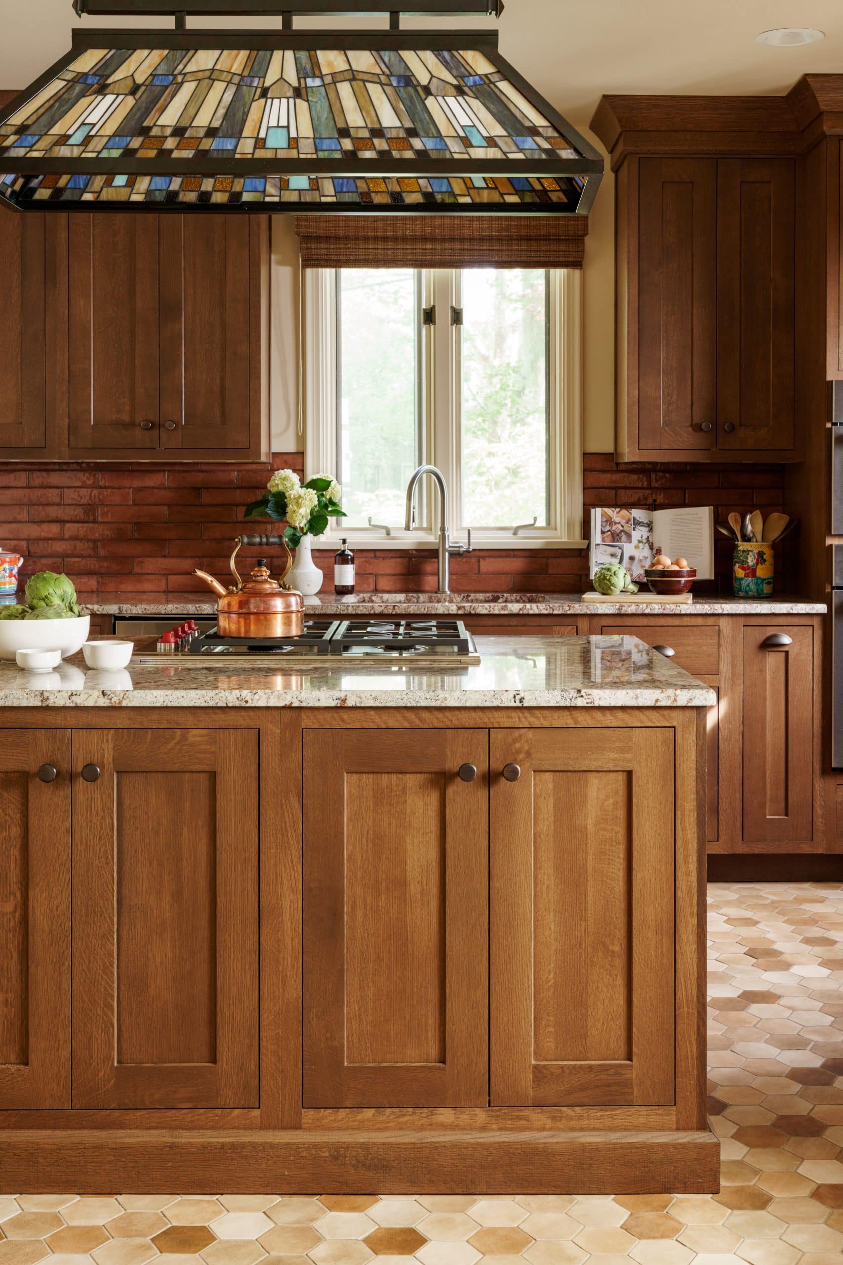 vertical details of warm wood tone charming craftsman kitchen in armour hills 