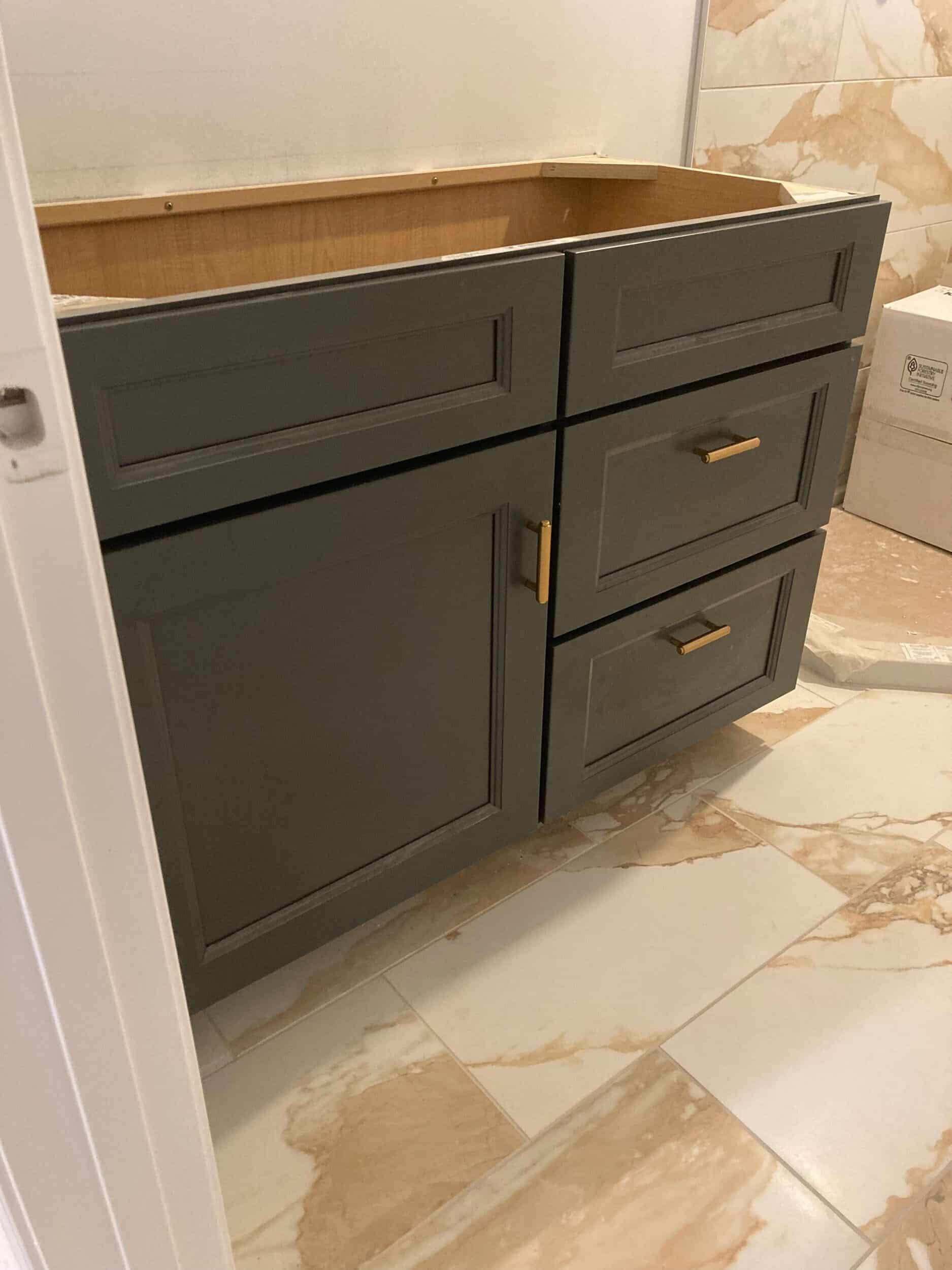 iron ore charcoal colored custom cabinetry installed with gold hardware in basement bathroom for prairie village basement remodel 