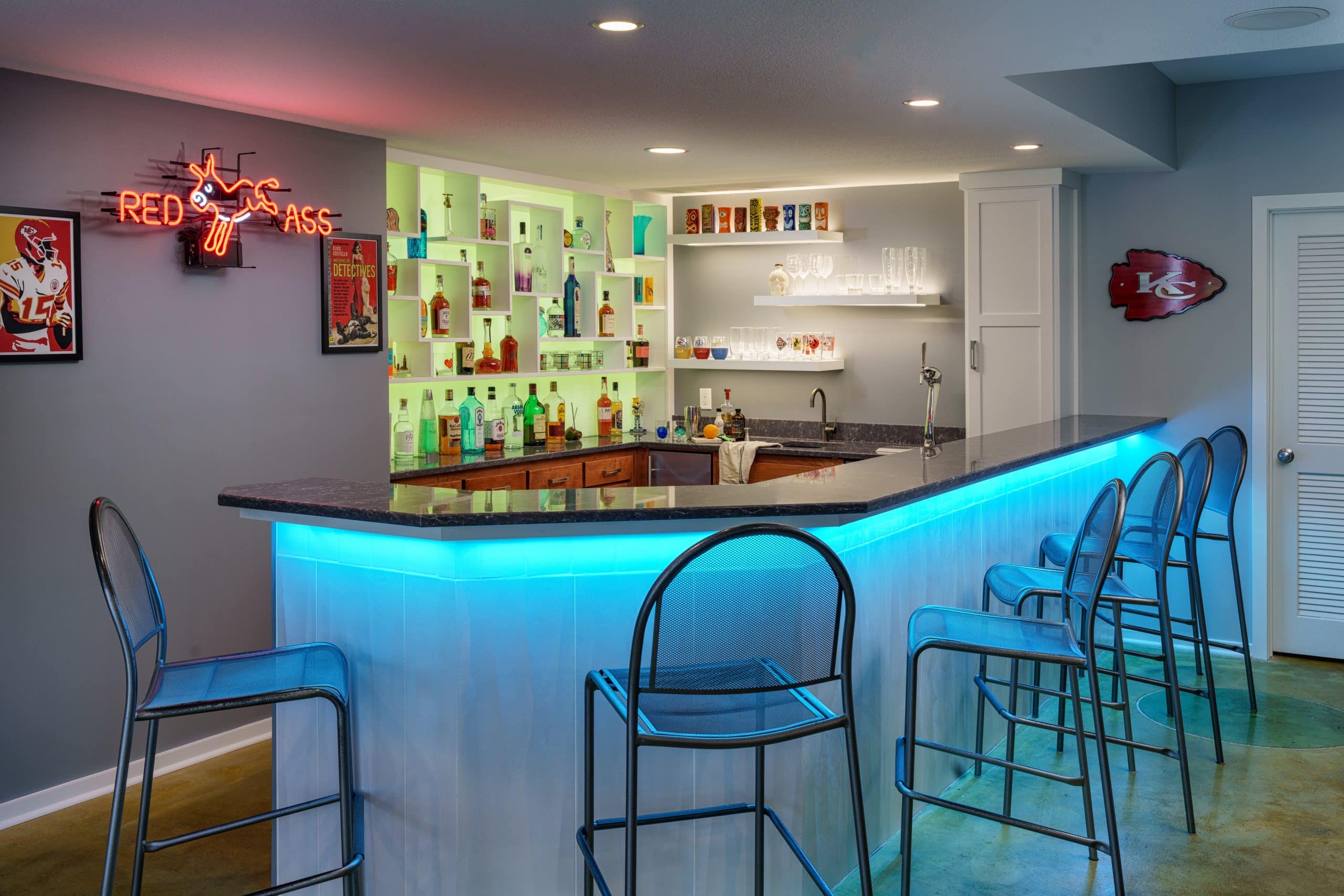 basement bar with neon lights and custom bottle display shelves