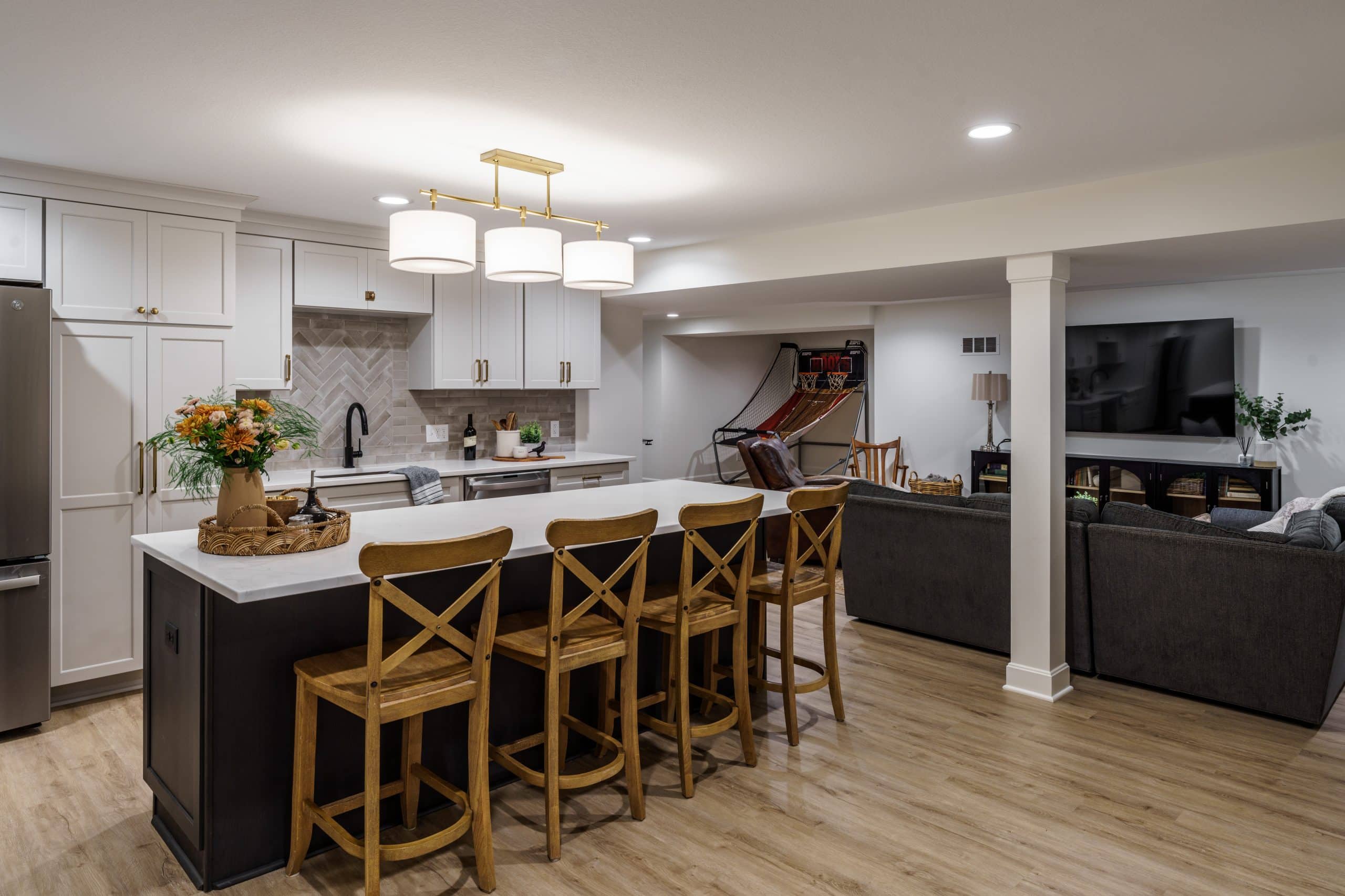 basement design with multiple zones ideal for hosting the watch party for the big game or any football game. a kitchen and wet bar, ample cozy seating and multiple zones
