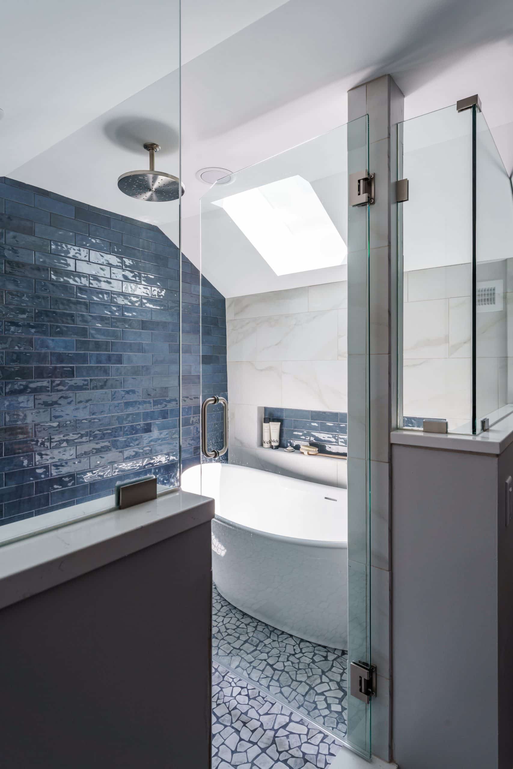 view into wetroom with tub and shower and bold blue tile