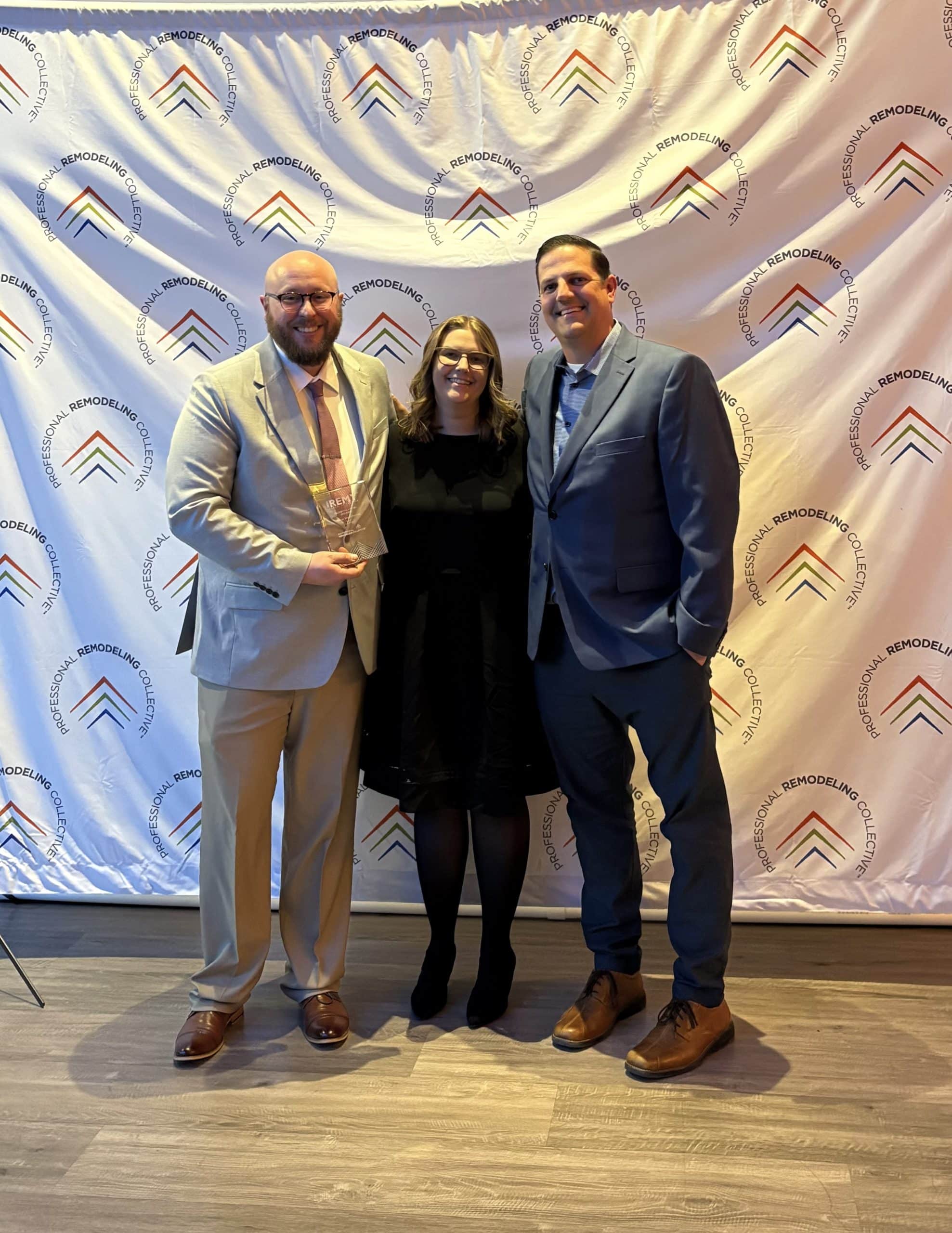 mark franklin and nina schmidt and andy gower accepting a REMY award for schloegel design remodel