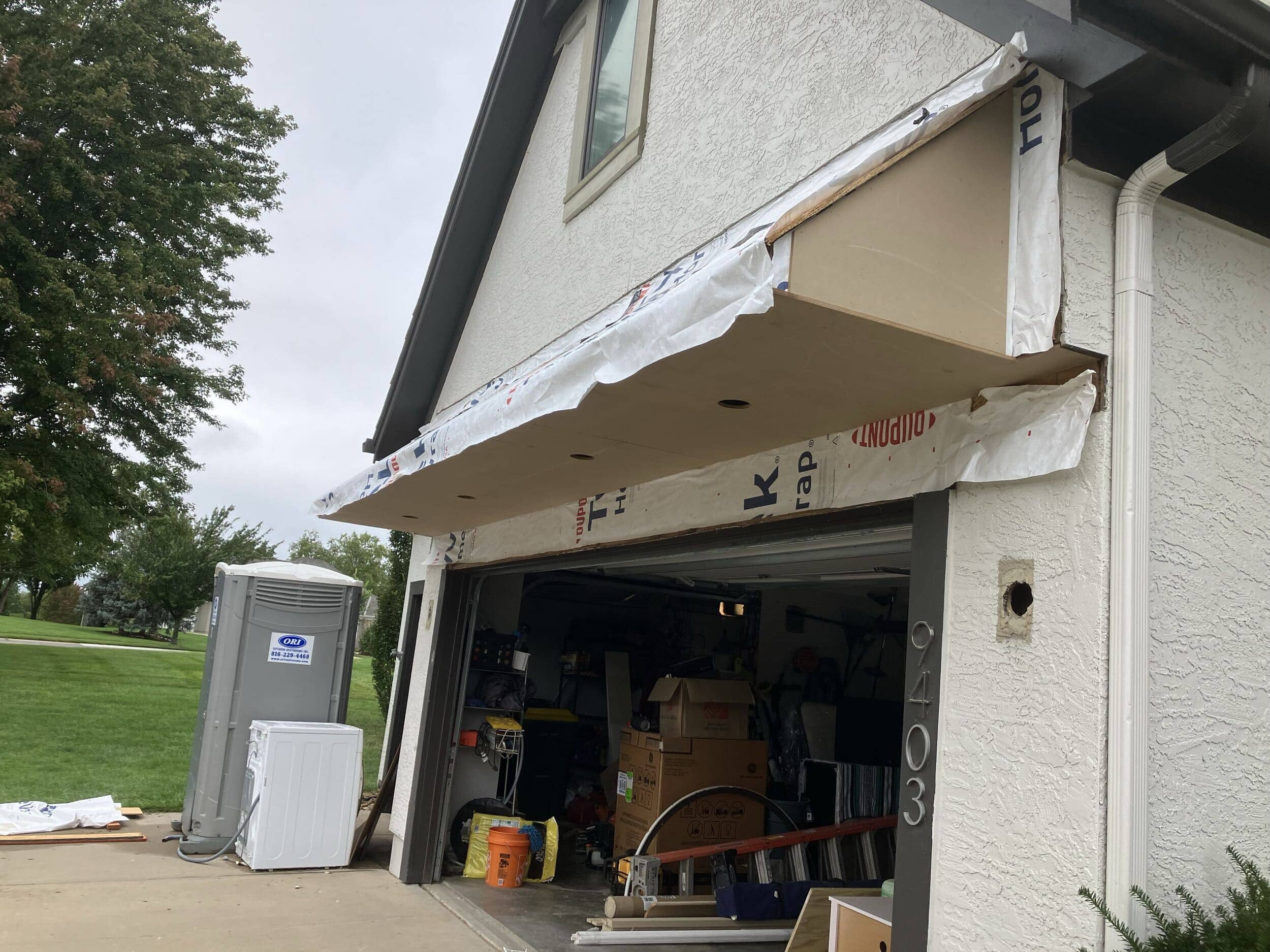 custom eyebrow roof overhang above garage door being installed