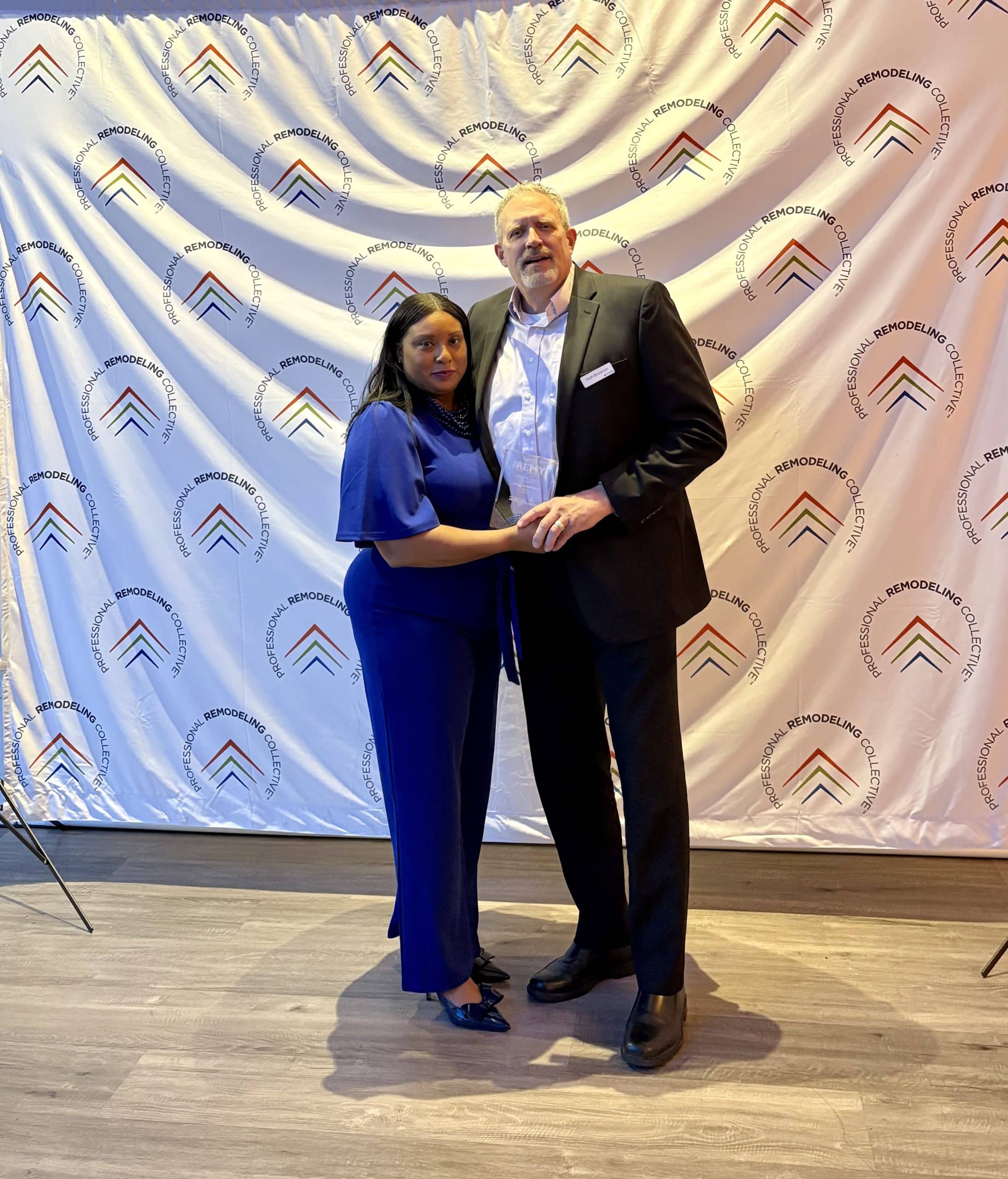 andrea stone and keith brockman from schloegel design remodel accepting a remy award