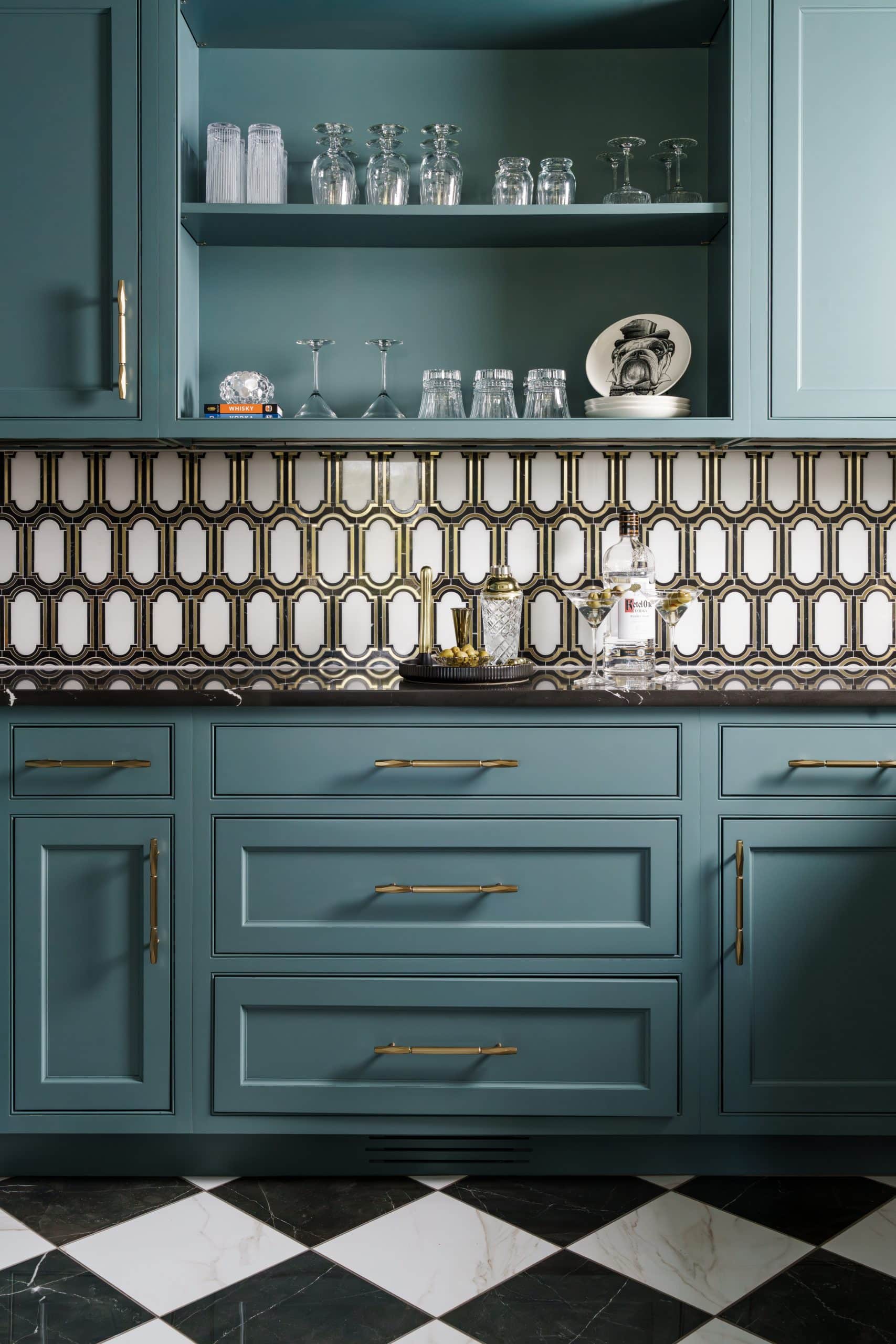 moody statement art deco inspired butler's pantry with deep teal cabinetry and black and white checkered floor tile and gold and white patterned backsplash tile