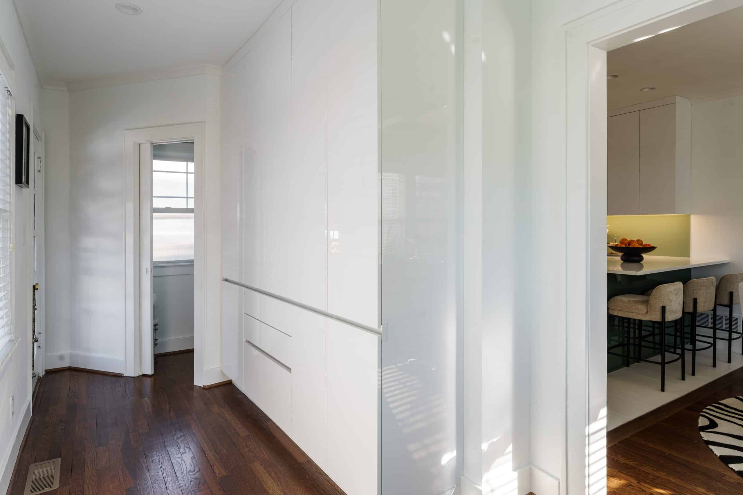 sleek modern white pantry storage in hall