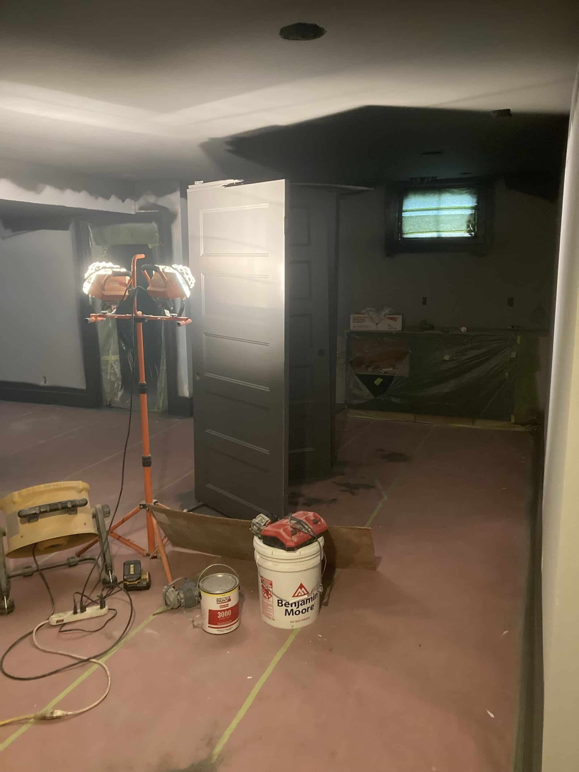 painting phase of remodel painting phase of basement remodel showing floor protection taped down and a light to see where the paint is being sprayed