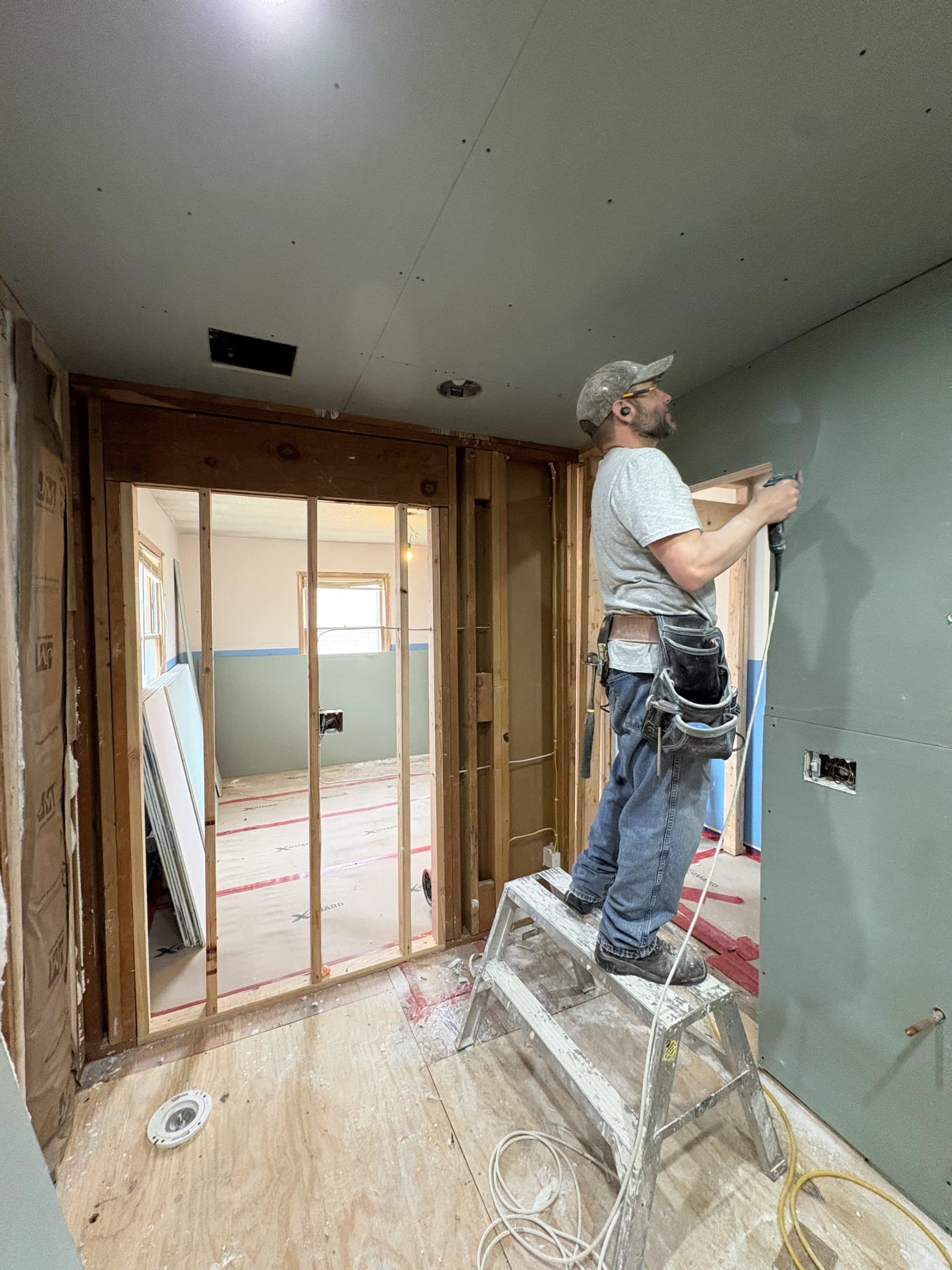 Tom Lee Drywall employee hanging drywall 